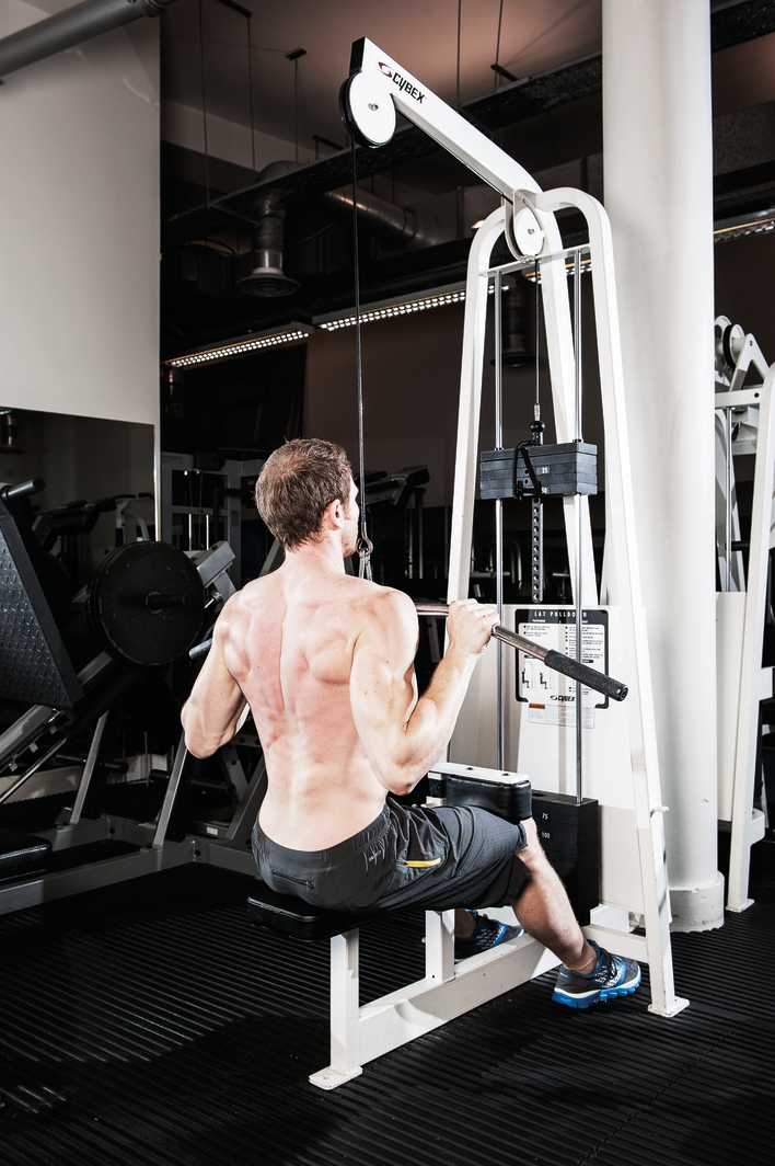 man demonstrates lat pull down how to build back muscles