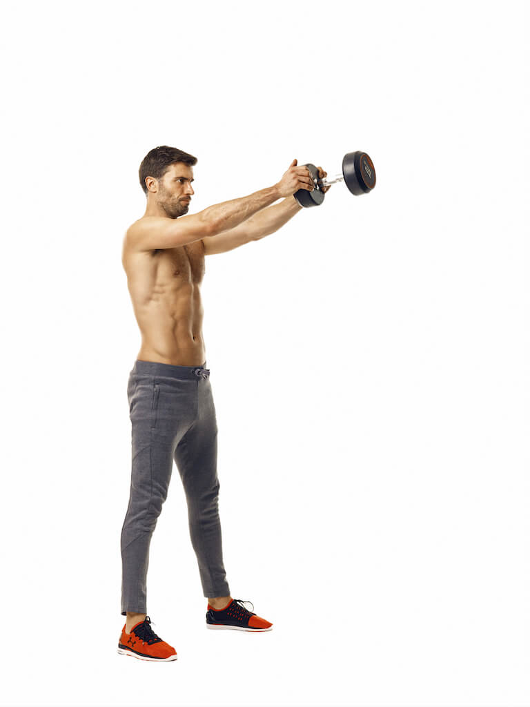 man demonstrates step two of dumbbell swing; standing upright, he swings the dumbbell out in front of him using both hands
