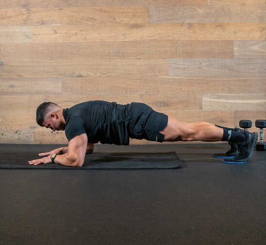man in low plank position, demonstrating body saw exercise