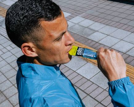 close up of runner using Science in Sport energy gel to demonstrate how to fuel for a half marathon