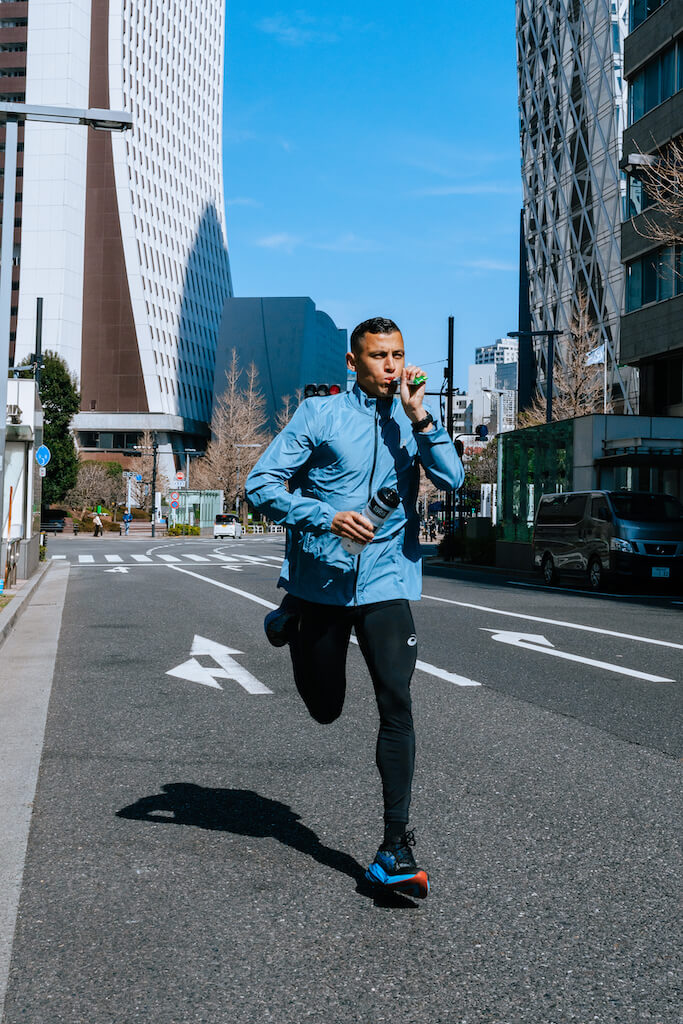 Runner running through quiet city streets taking science in sport energy gel