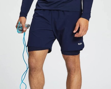 Lower torso of a man holding a skipping rope and wearing lined 7-inch shorts