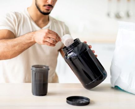 A man preparing a protein shake at home