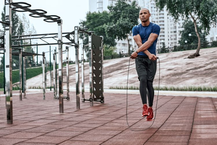 A man using a skipping rope in an outdoor gym