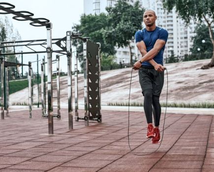 A man using a skipping rope in an outdoor gym