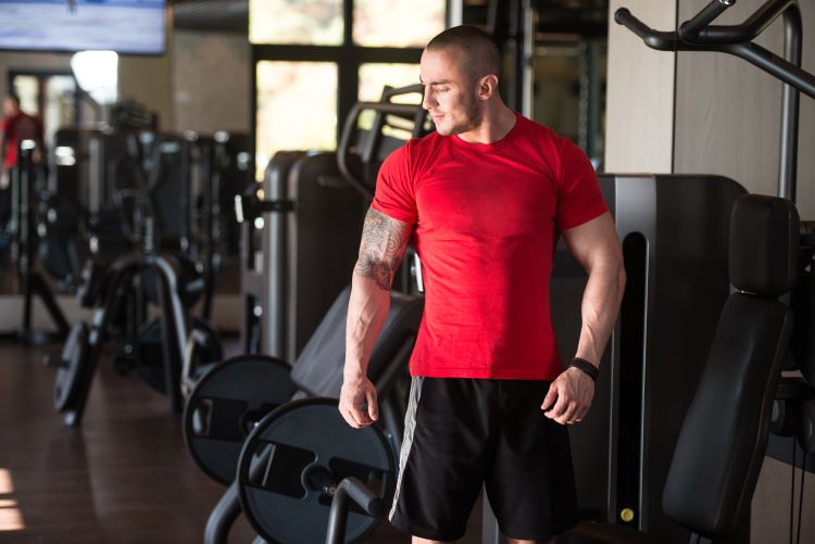 A man in a gym wearing a red t-shirt