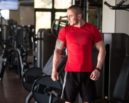 A man in a gym wearing a red t-shirt