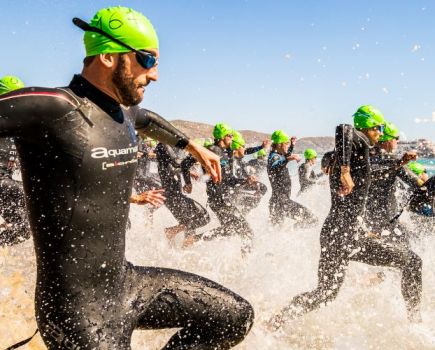 A group of male triathletes racing into the sea