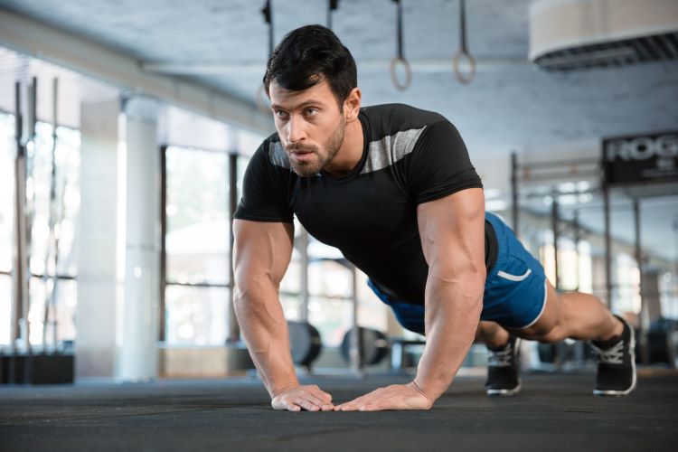 Man in a gym performing pushups