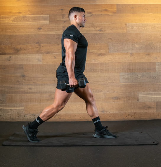 man demonstrates suitcase hold split squat in best full-body dumbbell workout