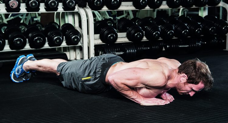 Man perfoming end of diamond press-up in gym - how to grow bigger arm muscles