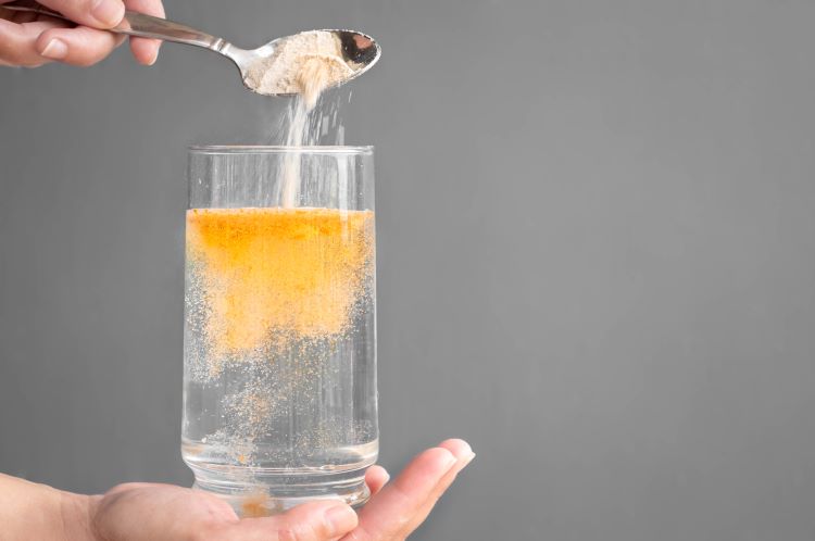Pouring orange electrolyte powder into water