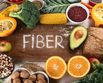 A selection of high fiber foods with the word fiber written in the middle