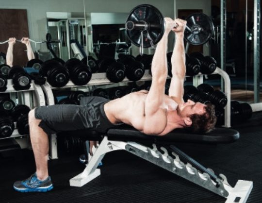 Man performing the lying triceps extension and pull-over - how to build bigger arm muscles