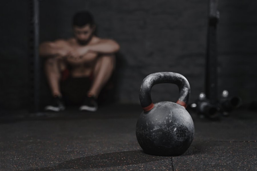 man sat down in the gym with kettlebell in the foreground to show lost exercise motivation