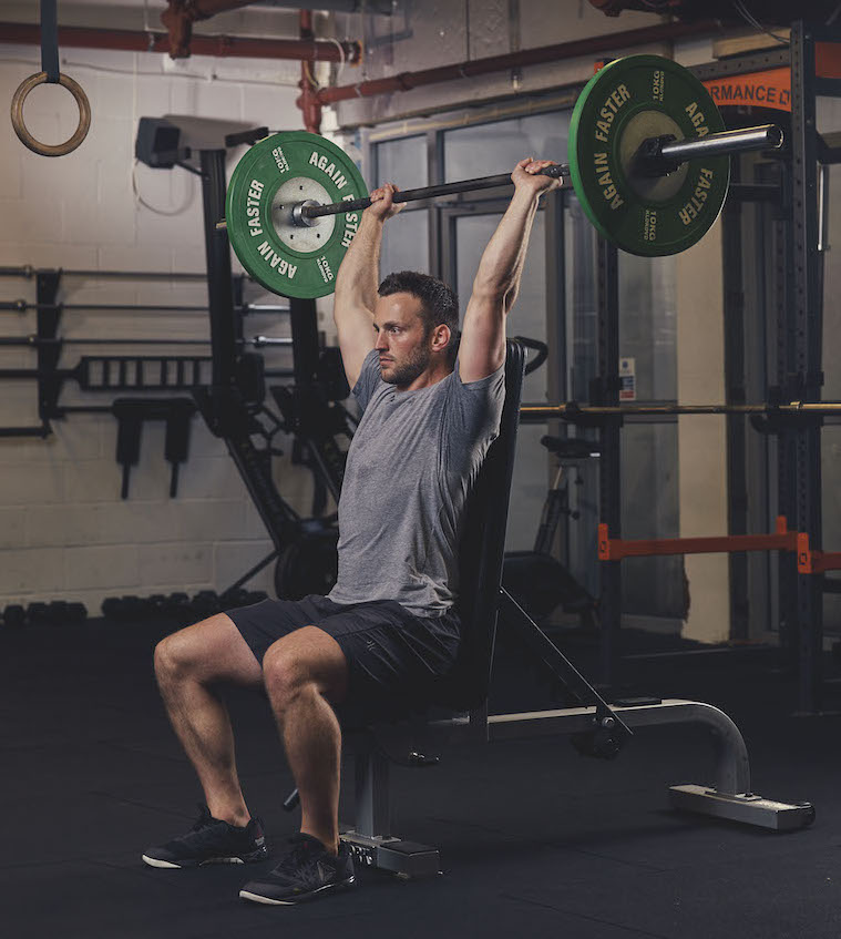 Man demonstrating a Barbell Seated Overhead Press 