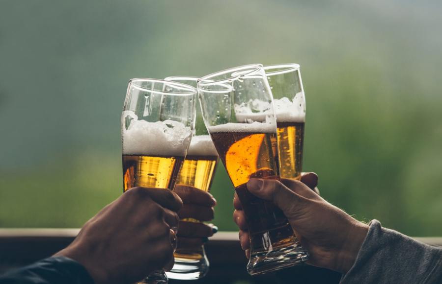four people cheers with glasses of beer