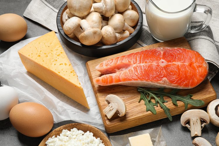 Food rich in vitamin D on a table - including salmon, eggs, mushrooms and cheese