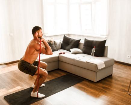 Man performing squat with resistance band