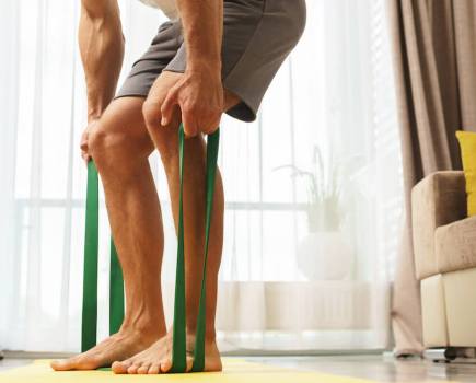 man performing resistance band row as part of resistance band upper body workout