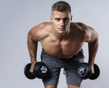 Man performing bent-over dumbbell row as part of a dumbbell-only upper-body workout