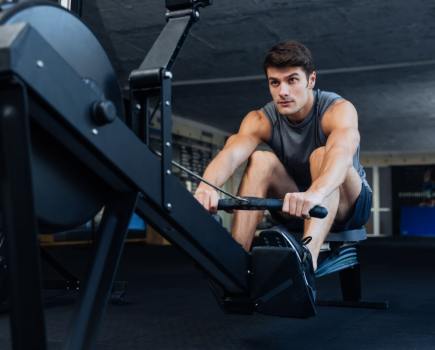 man working out at gym on rowing machine