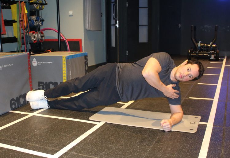 Man performing end of side bridge - best lower back exercises